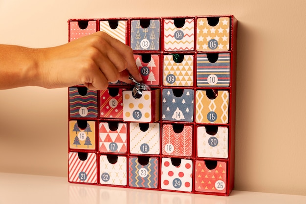 Main glissant une petite surprise dans une case du calendrier de l'Avent